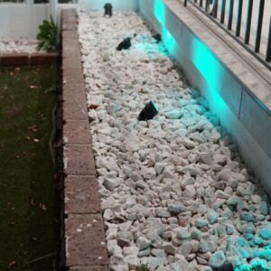 Elegant garden lighting with LED spotlights illuminating a stone-lined path and railing.