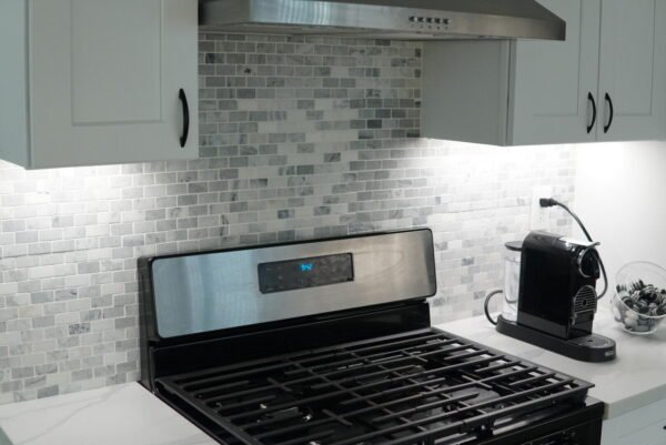 Bright under-cabinet lighting illuminating a kitchen stove area, enhancing visibility and functionality.