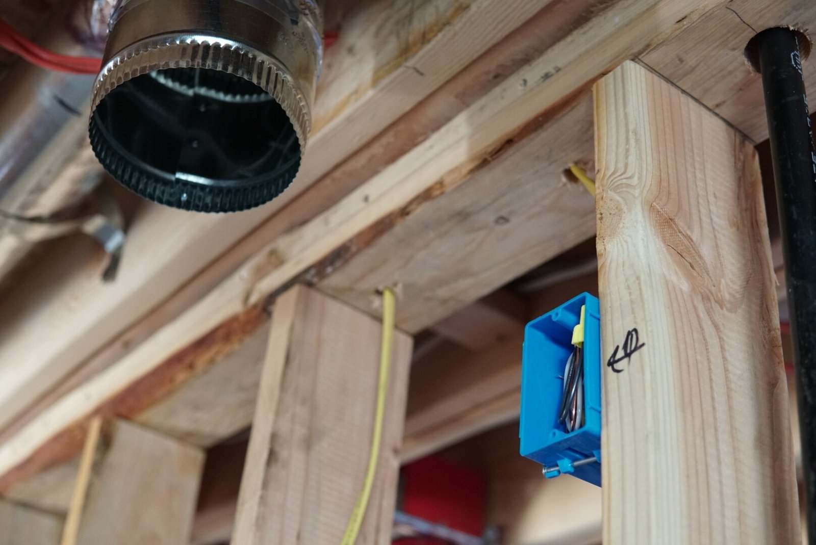 Technician performing partial rewiring to install a GFI for an oven hood during an electrical project.