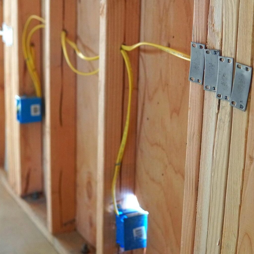 New construction wiring featuring GFCI wires, a GFCI electrical box, and visible framing, showcasing the progress of a residential electrical installation.