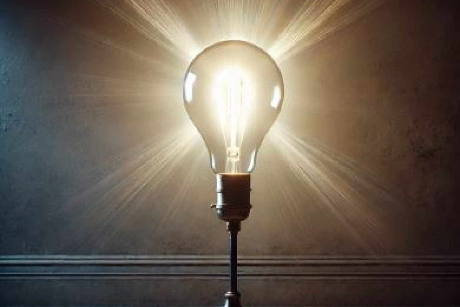 A flickering light bulb in a dimly lit room with an aged and eerie atmosphere, casting soft, intermittent shadows on peeling walls.